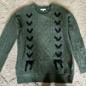 Green sweater with black bows.